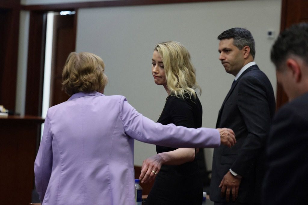 تتفاعل Amber Heard بجانب محاميها Elaine Bredehoft بعد أن أعلنت هيئة المحلفين عن أحكام منفصلة في 1 يونيو.