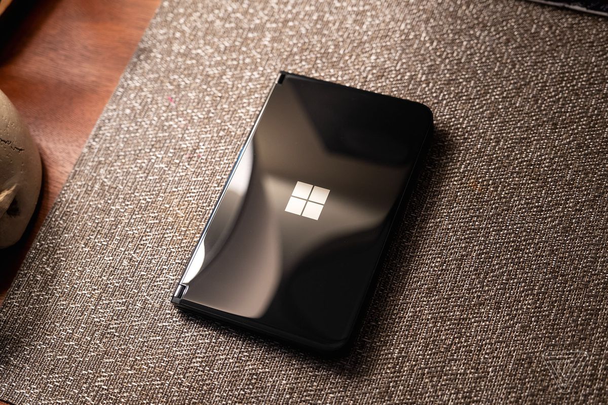 جهاز Microsoft Surface Duo 2 أسود مغلق ويجلس على مفرش.