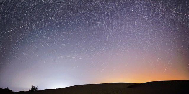 تُظهر الصورة المركبة التي تم التقاطها في 13 أغسطس 2021 السماء ليلاً خلال زخة نيزك بيرسيد فوق منطقة إيضاحية بيئية لإنغيبي في صحراء كوبوكي ، منطقة منغوليا الداخلية ذاتية الحكم في شمال الصين. 