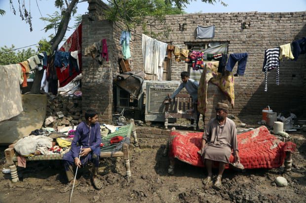 أسرة تأخذ قسطًا من الراحة بعد انتشال ممتلكاتها من منزلها الذي ضربه الفيضان ، في تشارسادا ، باكستان.