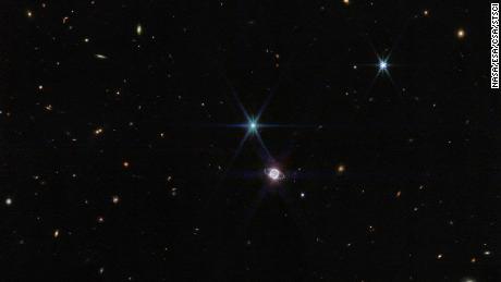 في هذه الصورة بواسطة Webb & # 39؛ s Near-Infrared Camera ، تظهر مجموعة صغيرة من مئات المجرات الخلفية ، متفاوتة الحجم والشكل ، بجانب نبتون.