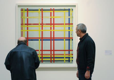 رجلان يتفقدان لوحة مدينة نيويورك الأولى التي رسمها بيت موندريان المعروضة في معرض بيت موندريان - فوم أبيلد زوم بيلد في متحف لودفيغ في كولونيا بألمانيا عام 2007.